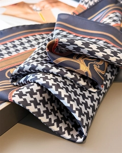 Detail of satin scarf with houndstooth print and golden chain pattern texture