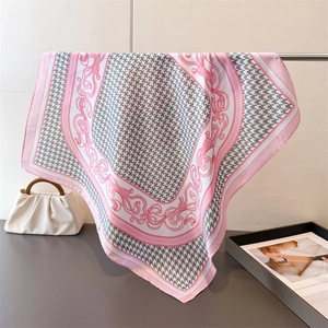 Detail of pink and grey houndstooth silk scarf with baroque floral patterns on display