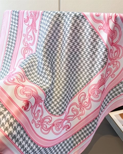 Detail of elegant grey houndstooth silk scarf with pink baroque patterns and satin sheen