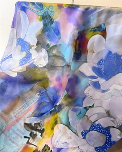 Detailed view of dragonfly and white floral prints on a silky scarf with vibrant colors