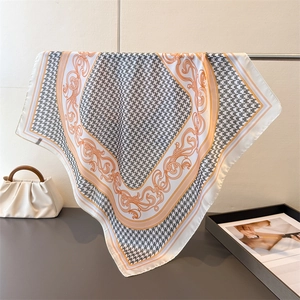 Detail of silk-like square scarf featuring houndstooth pattern and baroque gold accents