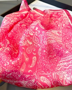 Détail d'un carré de soie imprimé paisley rose avec texture douce et drapé élégant