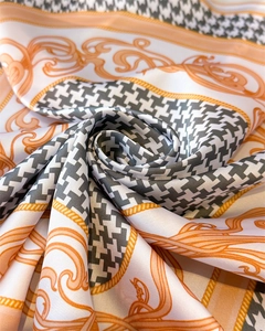 Detailed macro shot of houndstooth silk scarf folded into a rose showing smooth satin texture