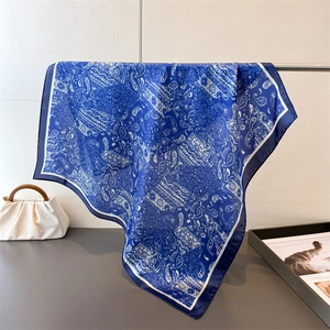 Détail montrant le drapé élégant et l'imprimé paisley d'un foulard en soie bleu marine