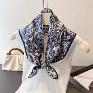 Carré de soie blanc à motif paisley noué sur mannequin avec finition satinée de luxe