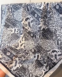 Détail du motif paisley et géométrique sur le foulard carré en satin noir et blanc