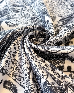 Détail macro du foulard en satin de soie imprimé cachemire avec reflets et plis élégants