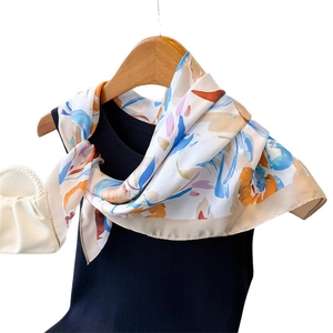 Foulard artistique en soie à fleurs noué sur un débardeur en maille bleu marine