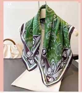 Detail of green and brown paisley silk scarf with glossy finish and wide border