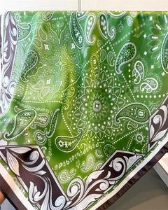Close-up of green paisley silk scarf with white mandala patterns and brown border