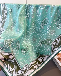 Detailed view of mint green paisley silk scarf showing soft drape and satin texture