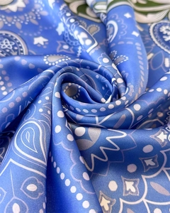 Macro detail of royal blue paisley silk scarf with glossy texture and swirl pattern
