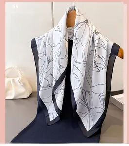 Detail of floral printed faux silk scarf draped on dress with pearl handbag accessory