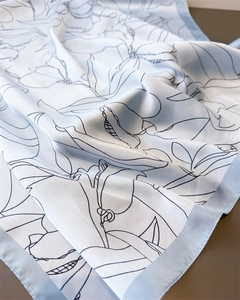 Detail of light blue floral faux silk scarf showing soft drapes and satin texture