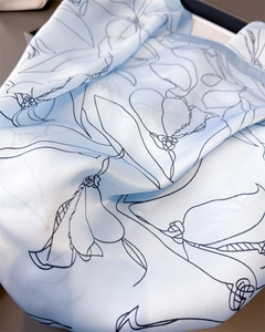 Detailed macro view of the silky smooth gradient blue fabric with floral linear patterns