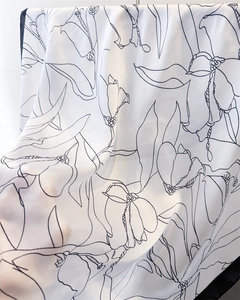 Close-up of lightweight printed silk scarf showing fine floral lines and edge stitching