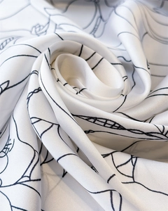 Detail of silk satin scarf showing botanical prints and glossy fabric texture