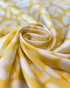 Detailed view of yellow leopard print silk scarf showing satin texture and glossy finish