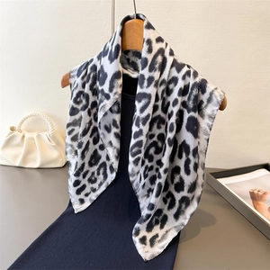 Elegant leopard print silk-feel square scarf styled on a hanger with fashion accessories