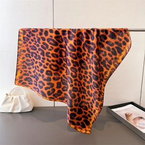 Close-up of leopard print silk scarf with orange-brown patterns hanging elegantly