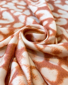 Macro view of silky leopard print fabric showing smooth texture and satin luster
