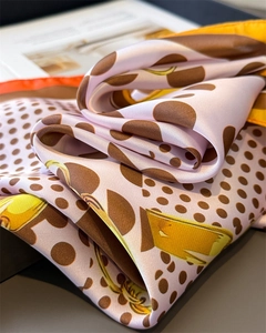 Detail of silk-feel scarf featuring polka dot chain prints and smooth fabric texture