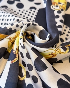 Macro shot of silk scarf showing polka dots, golden chains and premium texture