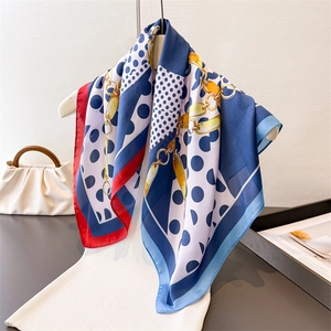 Polka dot and golden chain print silk scarf on a white mannequin for elegant styling