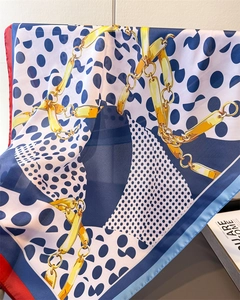 Detailed view of satin square scarf featuring golden chain print and navy polka dots