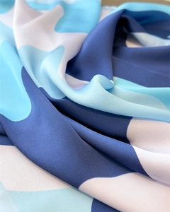 Detailed close-up of geometric pattern on high-quality blue and white silk scarf