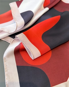 Macro shot of abstract geometric silk scarf featuring smooth satin texture and fine edge stitching