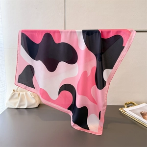 Detail of pink camouflage silk scarf showing the smooth satin texture and elegant drape