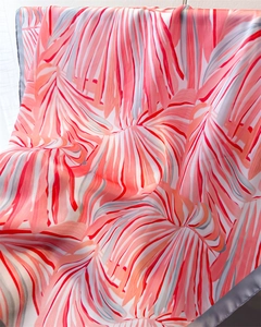 Détail d'un foulard en soie à imprimé palmier tropical avec bordure rose et grise chic