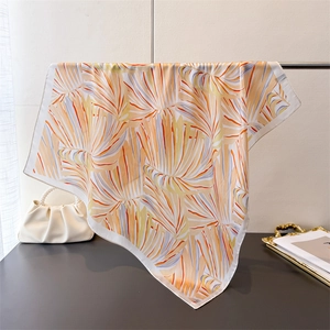 Détail du foulard en soie avec motifs botaniques colorés et bordure blanche de haute qualité