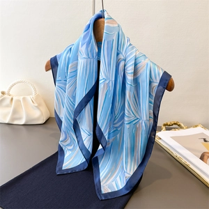 Élégant foulard en soie à imprimé palmier bleu et bordure marine sur cintre en bois