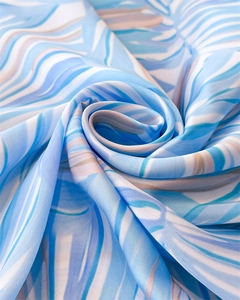 Détail d'un foulard en satin aspect soie avec motifs de feuilles de palmier bleues