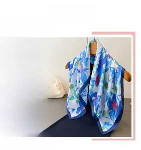 Detail of blue floral satin scarf with elegant classic pattern and silky texture finish