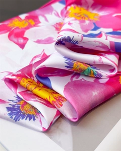 Macro shot of vibrant pink floral print on glossy white satin silk square scarf