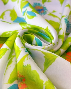 Close-up of elegant silk-like scarf with vibrant floral and green leaf patterns