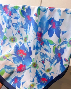 Macro detail of blue floral print silk-like scarf showing smooth texture and edge stitching