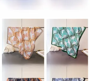 Dettaglio di sciarpe quadrate in finta seta con motivo a piume in marrone e verde elegante