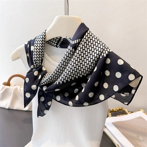 Elegant black and white polka dot faux silk scarf tied on a white mannequin torso