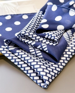 Detail of silk-satin scarf with white polka dots and navy blue geometric patterns