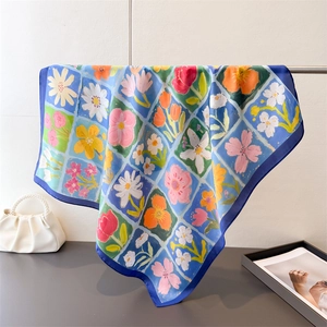 Dettaglio foulard in seta con fiori dipinti a olio ed eleganti bordi blu scuro cuciti