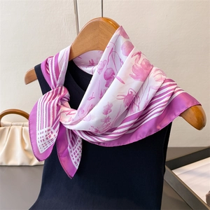 Detail of a floral print silk-like scarf tied on a hanger showing drape and texture