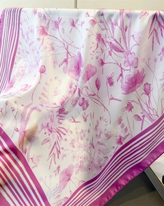 Detail of floral printed silk scarf showing soft drape and magenta pattern on white fabric