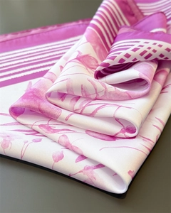 Detailed view of the elegant pink and white floral silk scarf with a smooth pearlescent texture