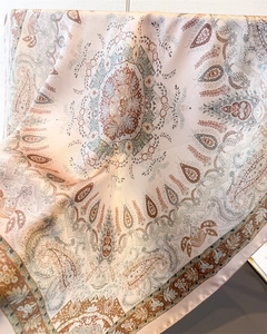 Detail of elegant paisley print silk scarf with satin finish and soft pink mandala patterns