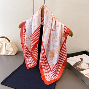 Elegant floral print orange silk square scarf hanging on wooden hanger for women