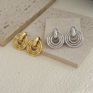 Detailed view of layered geometric hoop earrings in polished gold and silver finishes